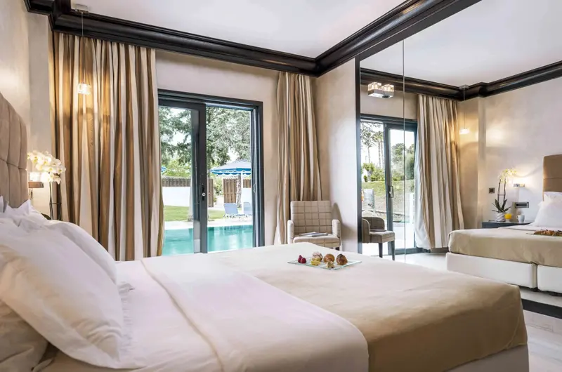 Une chambre lumineuse avec un lit double et un accès à une piscine.