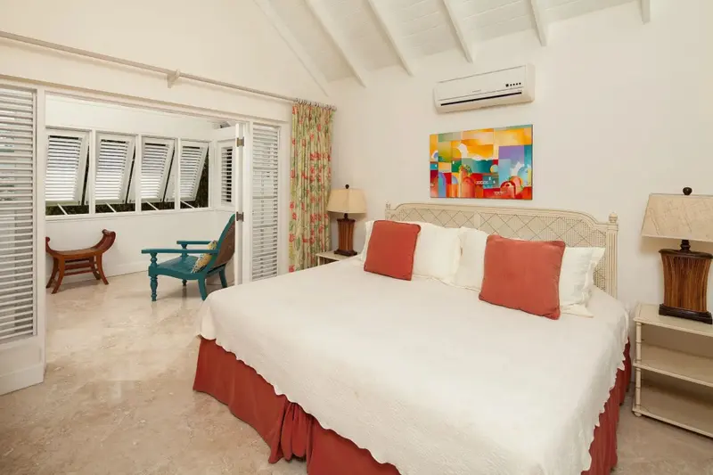 Une chambre lumineuse avec un grand lit et un coin salon.