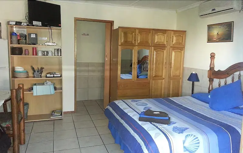 Une chambre lumineuse avec un grand lit et un meuble de rangement.