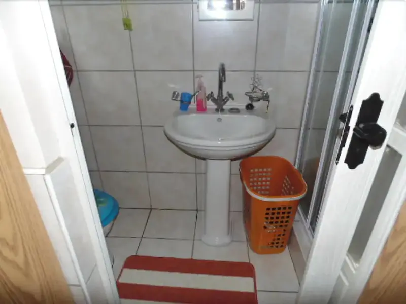 Une salle de bain carrelée avec un lavabo et une douche.