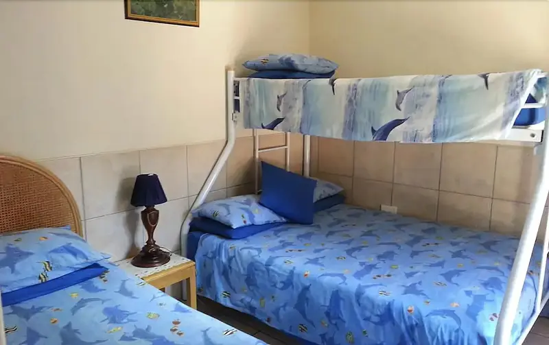 Une chambre avec des lits superposés et un lit simple.