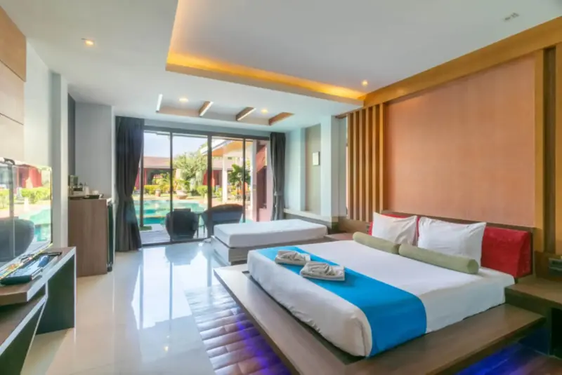 Une chambre lumineuse avec un grand lit et un accès à une piscine extérieure.