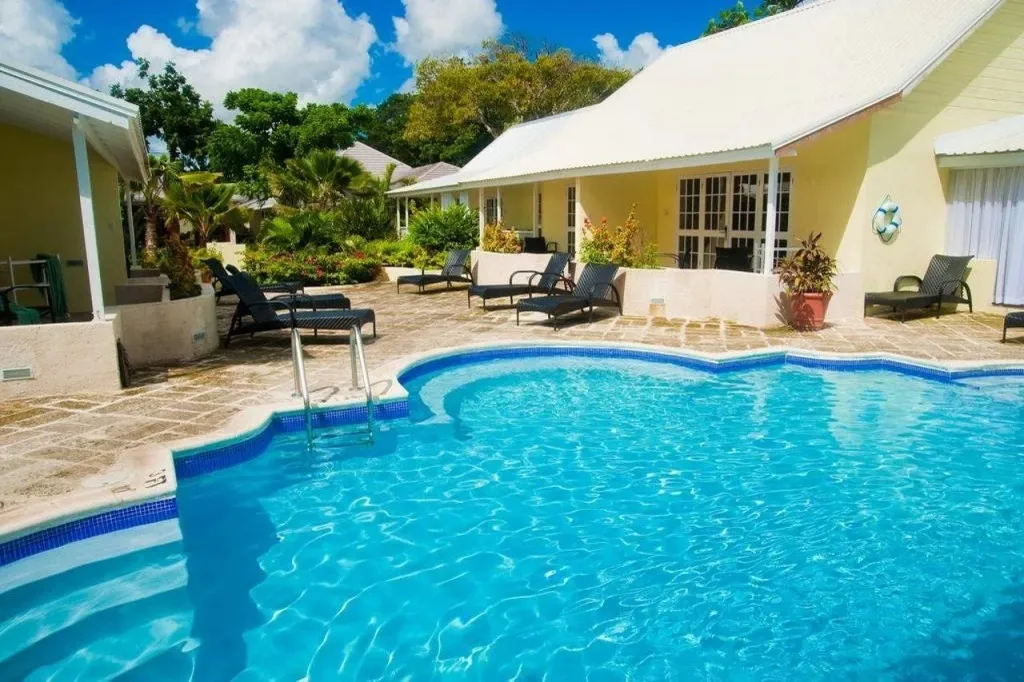 Une piscine turquoise invite à la détente dans un cadre tropical ensoleillé.