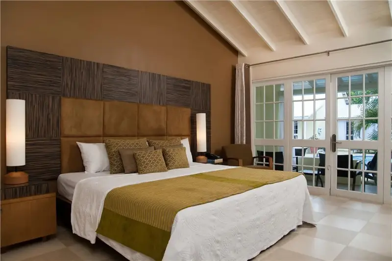 Une chambre lumineuse avec un grand lit et un accès à une terrasse.