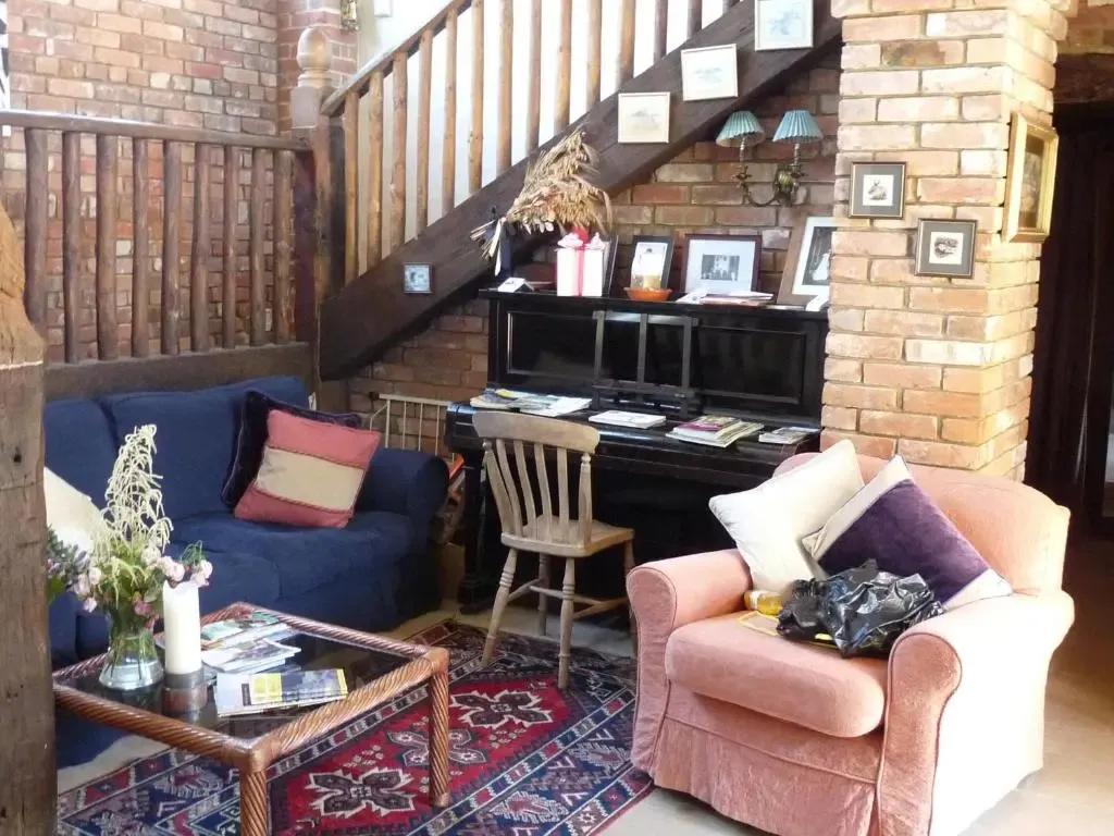 Un salon chaleureux avec des canapés, des fauteuils et un piano.
