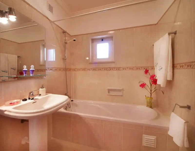 Une salle de bain lumineuse avec baignoire et lavabo.