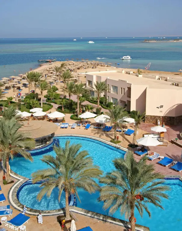 Vue aérienne d'un complexe hôtelier avec piscine et accès à la mer.