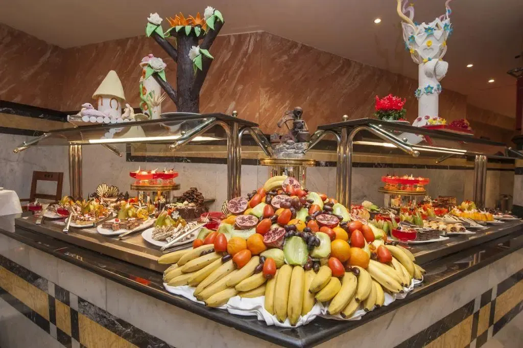Un buffet propose une grande variété de fruits frais et de pâtisseries.
