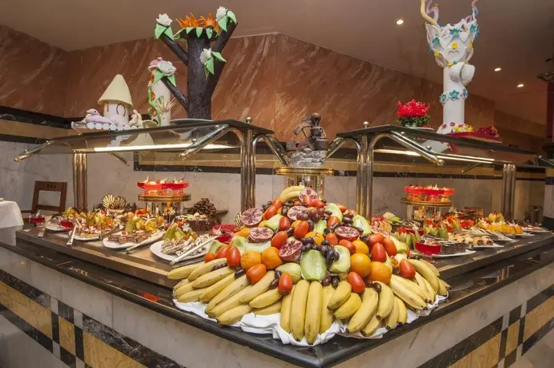 Un buffet propose une grande variété de fruits frais et de pâtisseries.