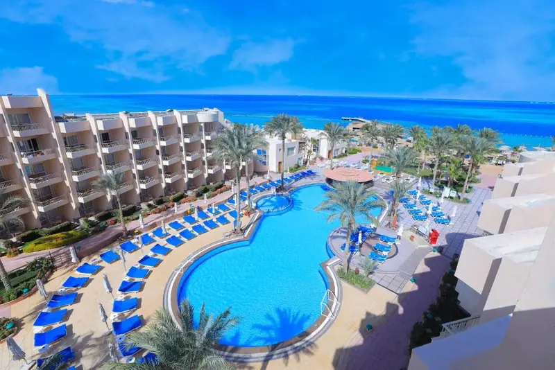 Vue aérienne d'un complexe hôtelier avec piscine et accès à la mer.