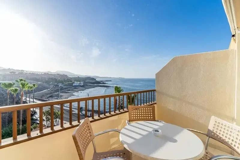 Une terrasse ensoleillée offre une vue dégagée sur la mer et le littoral.