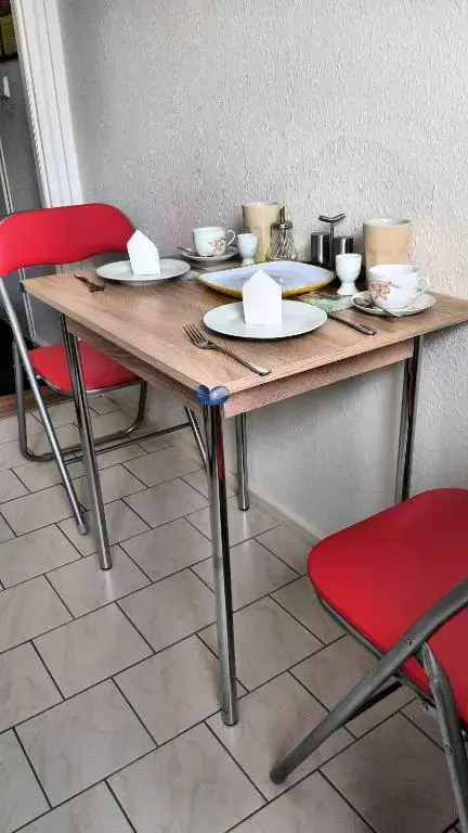 Une table est dressée pour le petit-déjeuner avec de la vaisselle et des couverts.