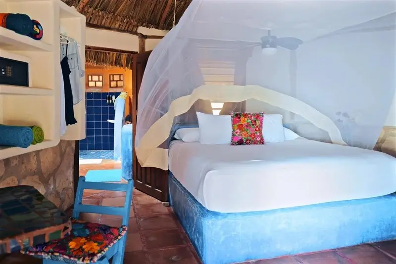 Une chambre lumineuse avec un grand lit à baldaquin et une décoration colorée.