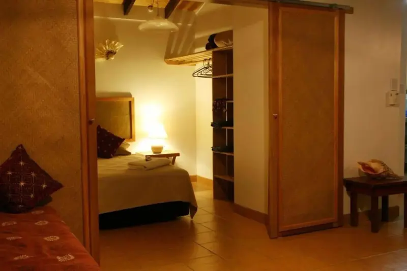 Une chambre lumineuse avec un lit et un placard ouvert.