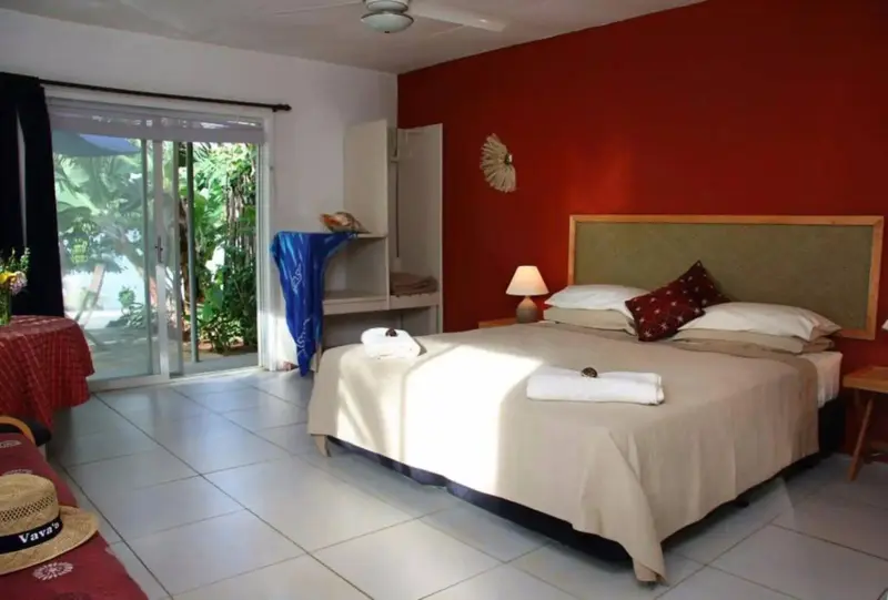 Une chambre lumineuse avec un grand lit et un accès à une terrasse.