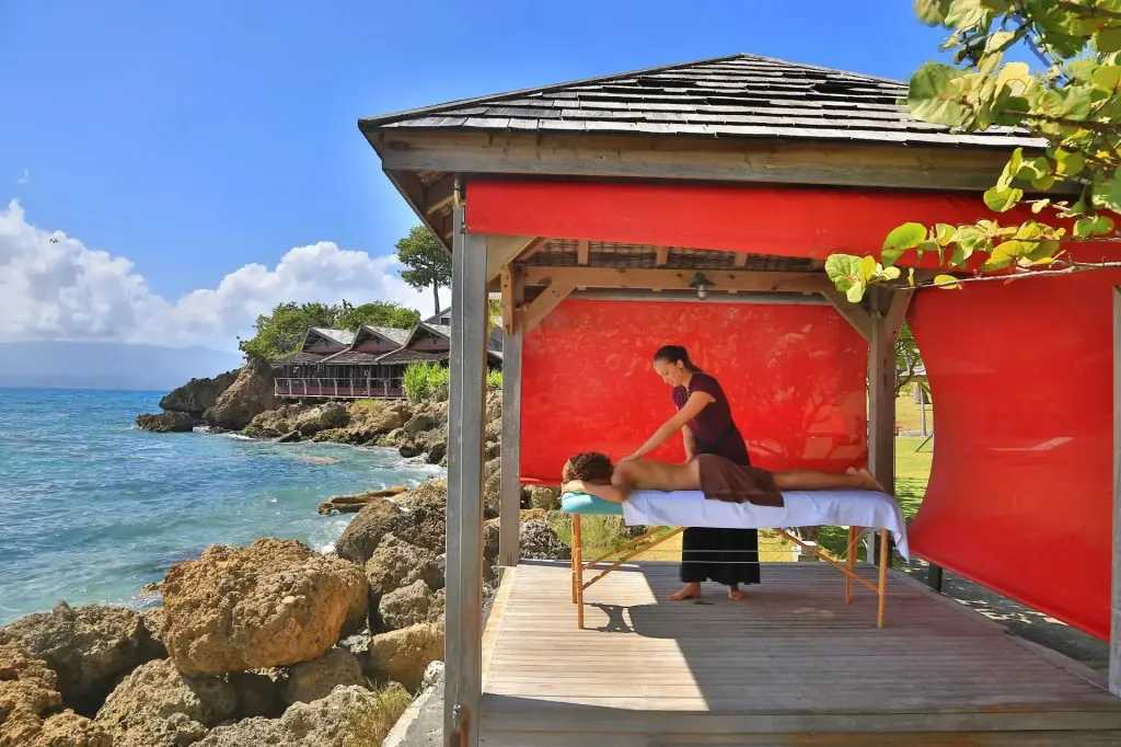 Une personne reçoit un massage en extérieur, face à la mer.