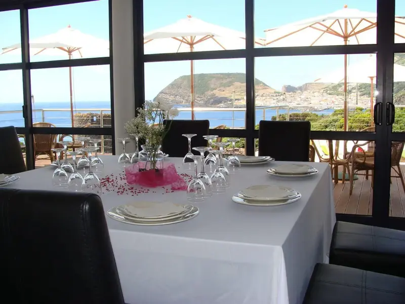 Une table dressée avec vue sur la mer et la côte.