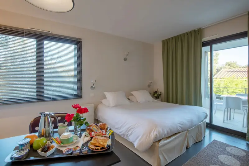 Une chambre lumineuse avec un petit-déjeuner servi sur un plateau.