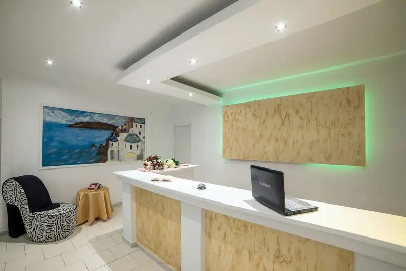 Un comptoir d'accueil moderne avec un ordinateur portable et des arrangements floraux.
