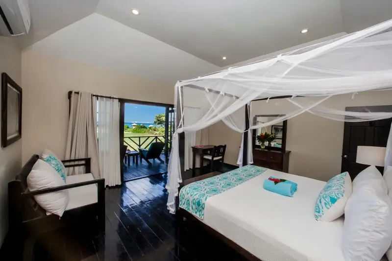 Une chambre lumineuse s'ouvre sur une terrasse avec vue sur la mer.