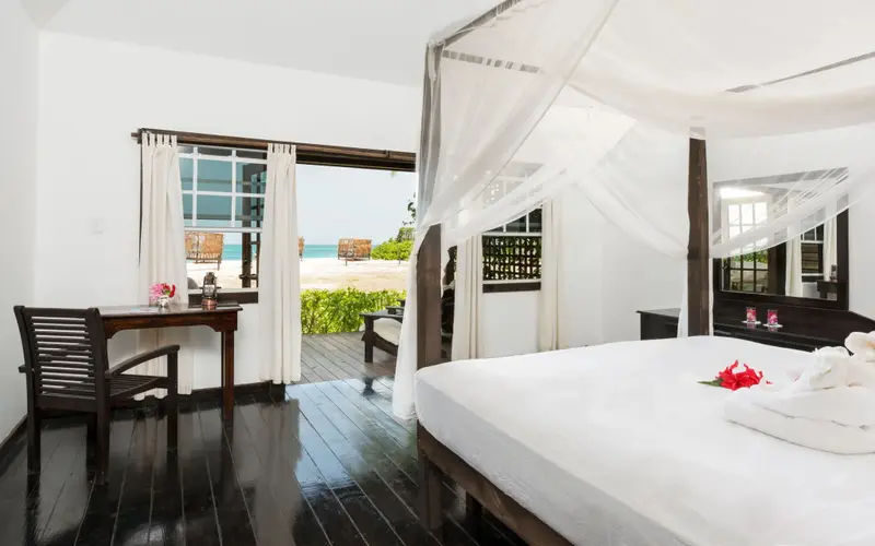 Une chambre lumineuse s'ouvre sur une terrasse donnant sur la plage.