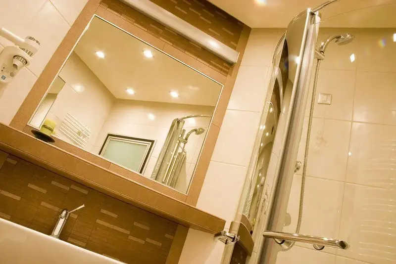 Une salle de bain moderne avec douche et miroir.