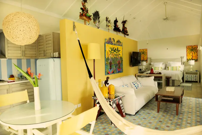 Une piece lumineuse combine un espace repas, un coin salon et une chambre a coucher.