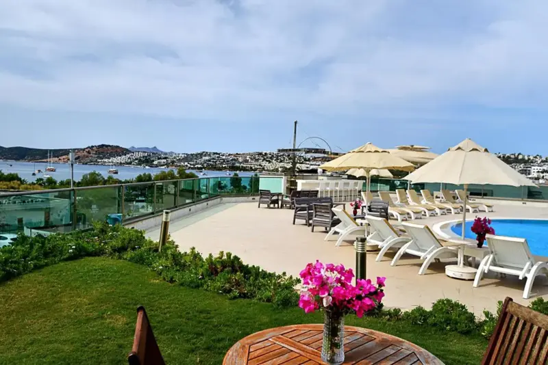 Terrasse avec transats et piscine donnant sur une vue panoramique.