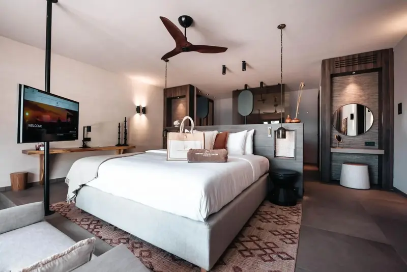 Une chambre lumineuse avec un grand lit recouvert de linge blanc.