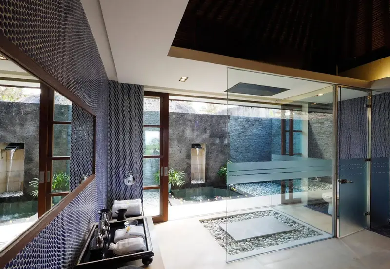 Une salle de bain moderne avec une douche extérieure et des parois vitrées.