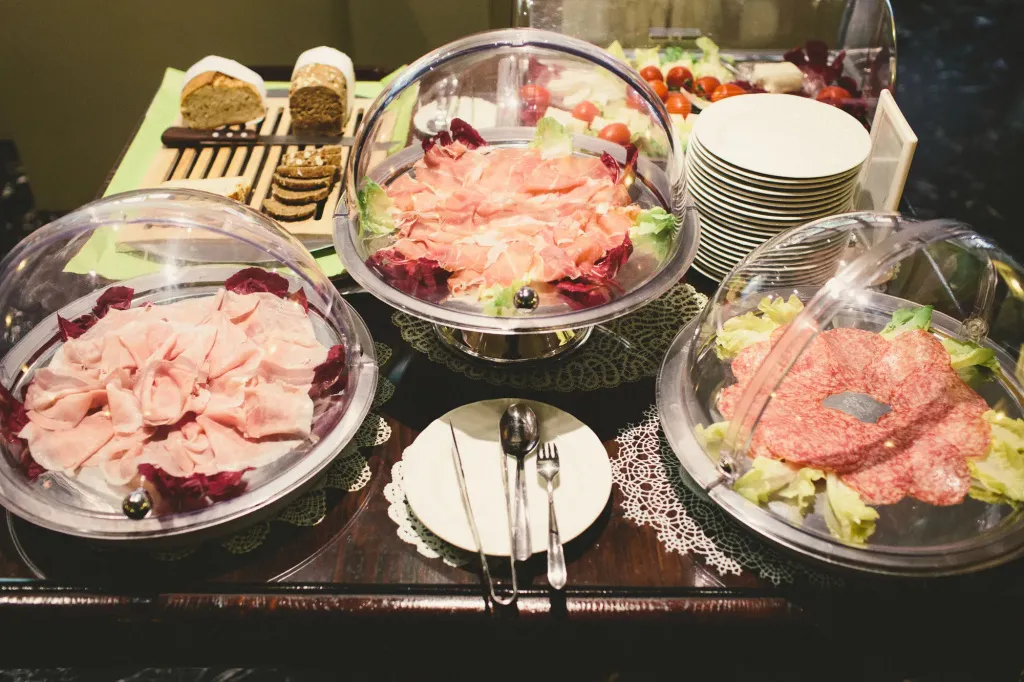 Présentation de charcuteries et de salades sur un buffet.