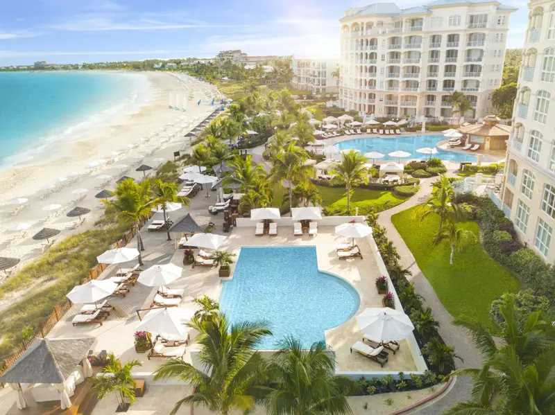 Vue aérienne d'un complexe hôtelier avec piscine et plage.