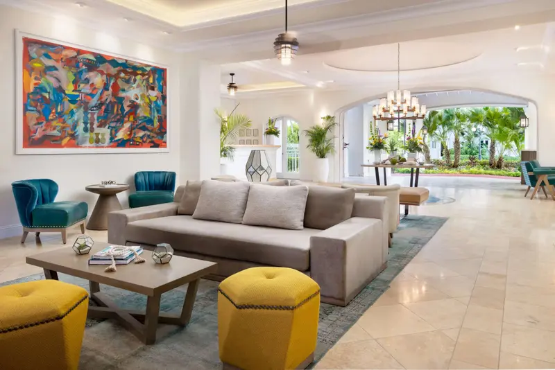 Espace de détente intérieur avec canapés et fauteuils colorés.