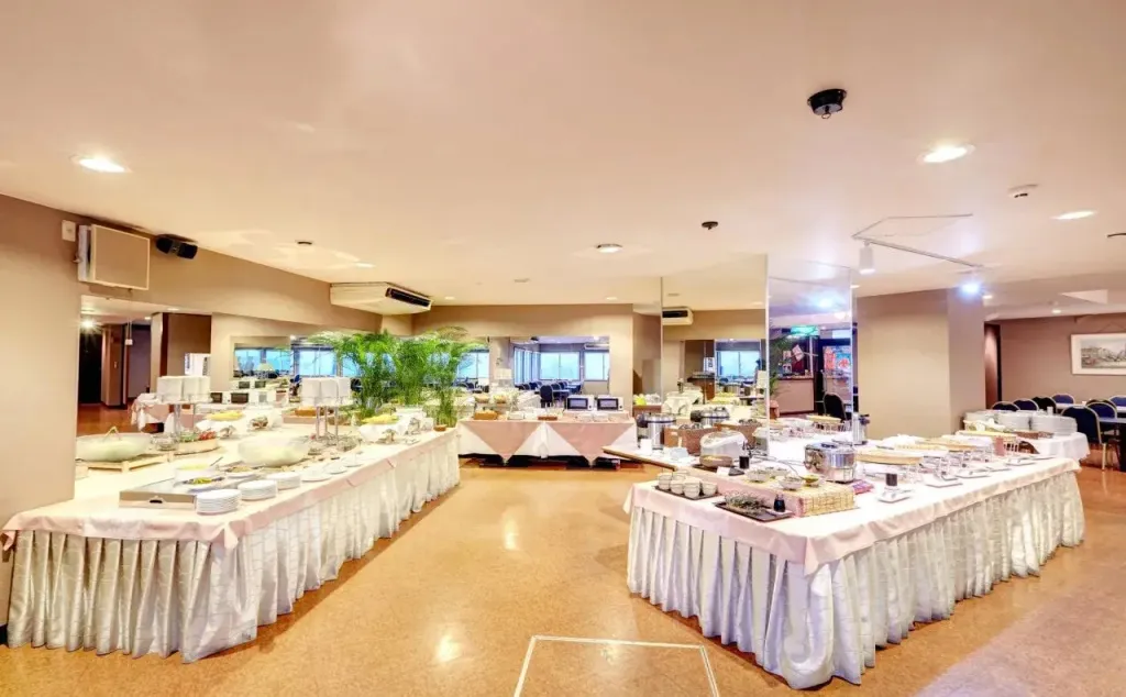 Une salle lumineuse présente un buffet garni de plats variés.