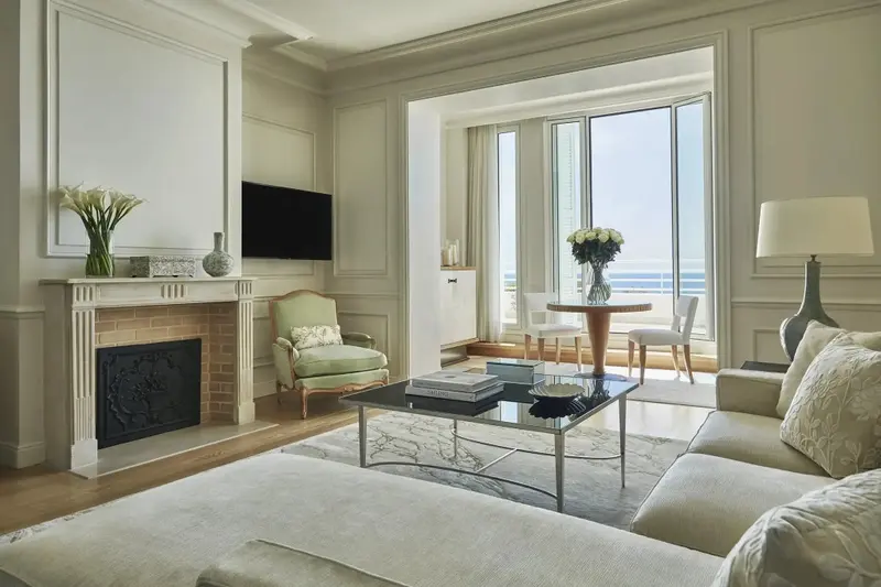 Un salon lumineux avec un canapé et une table basse, donnant sur une vue mer.