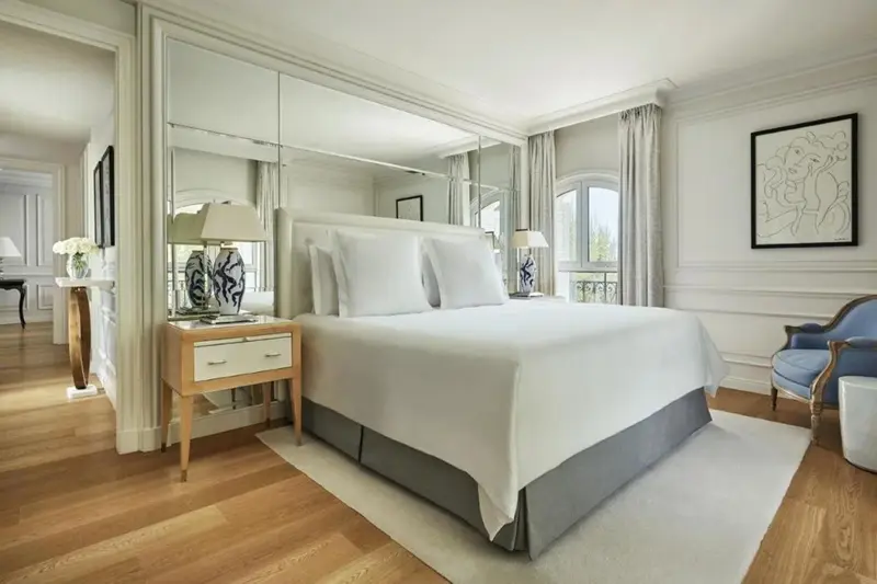 Une chambre lumineuse avec un grand lit et des miroirs.