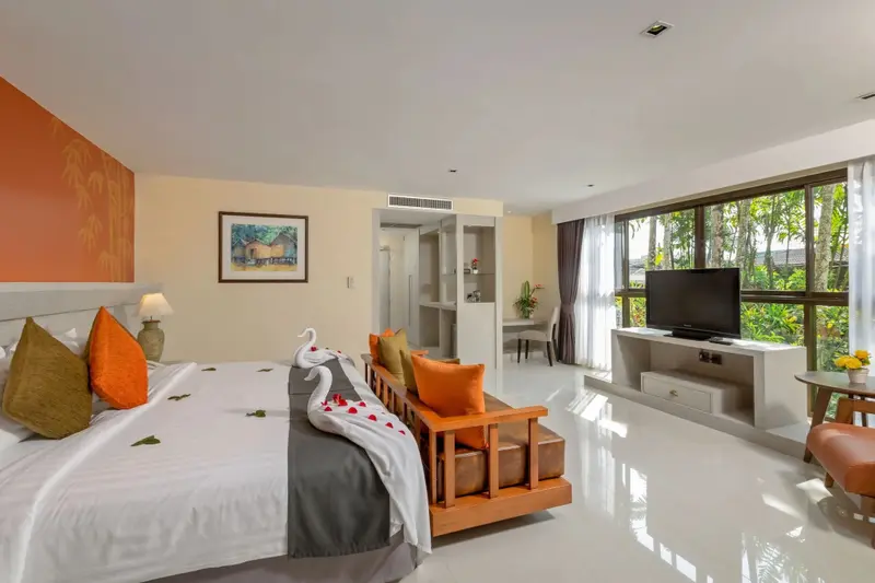 Une chambre lumineuse avec un grand lit et un espace détente.
