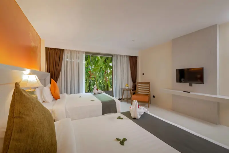 Une chambre lumineuse avec deux lits et une vue sur la végétation.