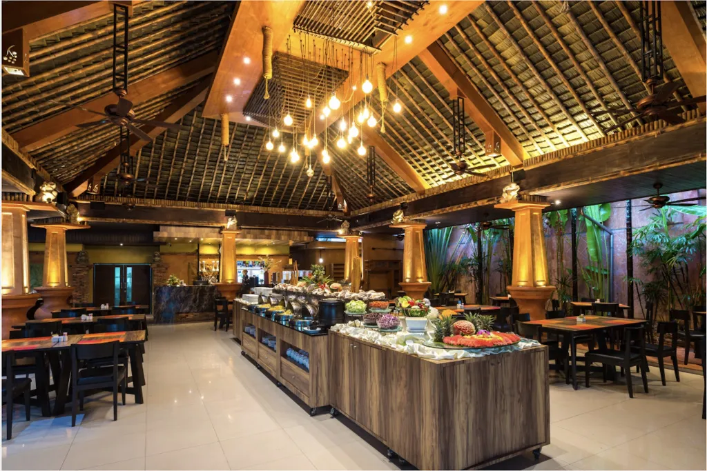 Une salle lumineuse avec un buffet garni et des tables à manger.