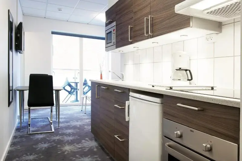 Une cuisine moderne avec un plan de travail, des placards et un four.