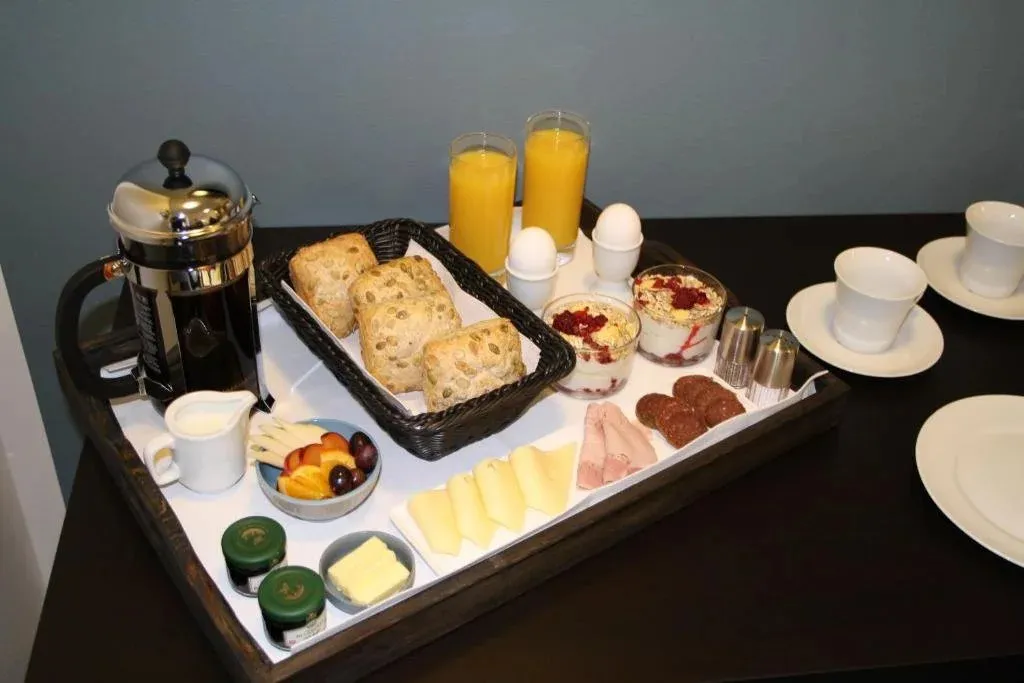 Un plateau de petit-déjeuner garni est présenté sur une surface sombre.
