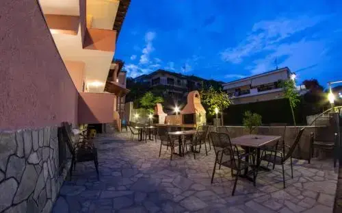 Terrasse aménagée avec tables et chaises devant un bâtiment éclairé.