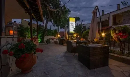Terrasse ombragée avec mobilier de jardin et végétation fleurie.