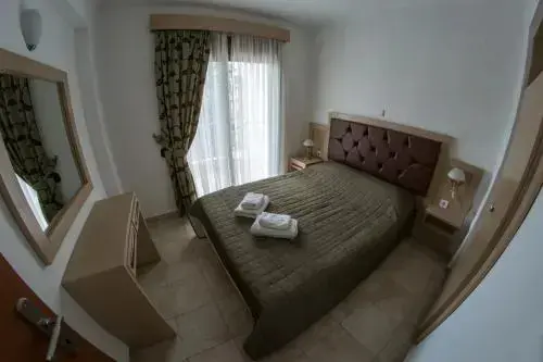 Une chambre lumineuse avec un grand lit et un miroir.