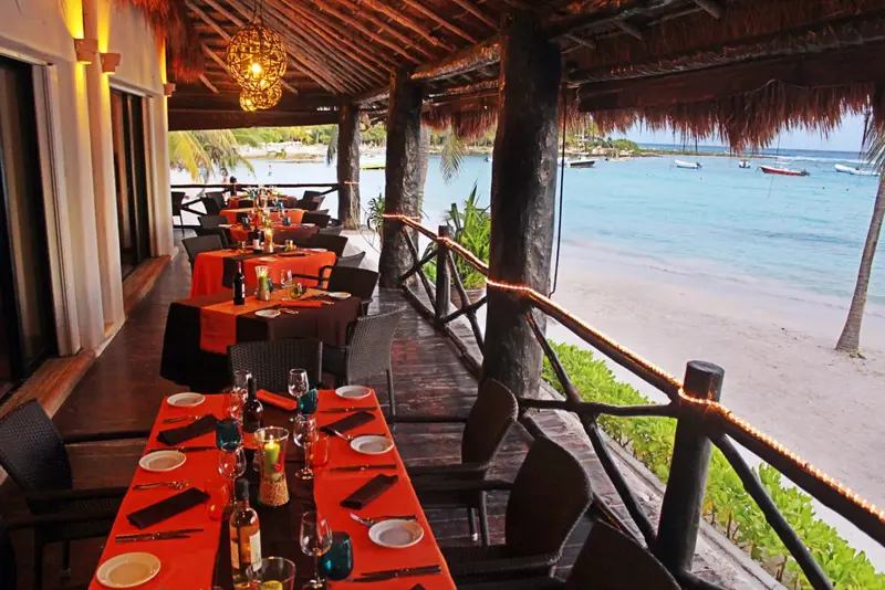 Une salle à manger en plein air offre une vue sur la plage et la mer.