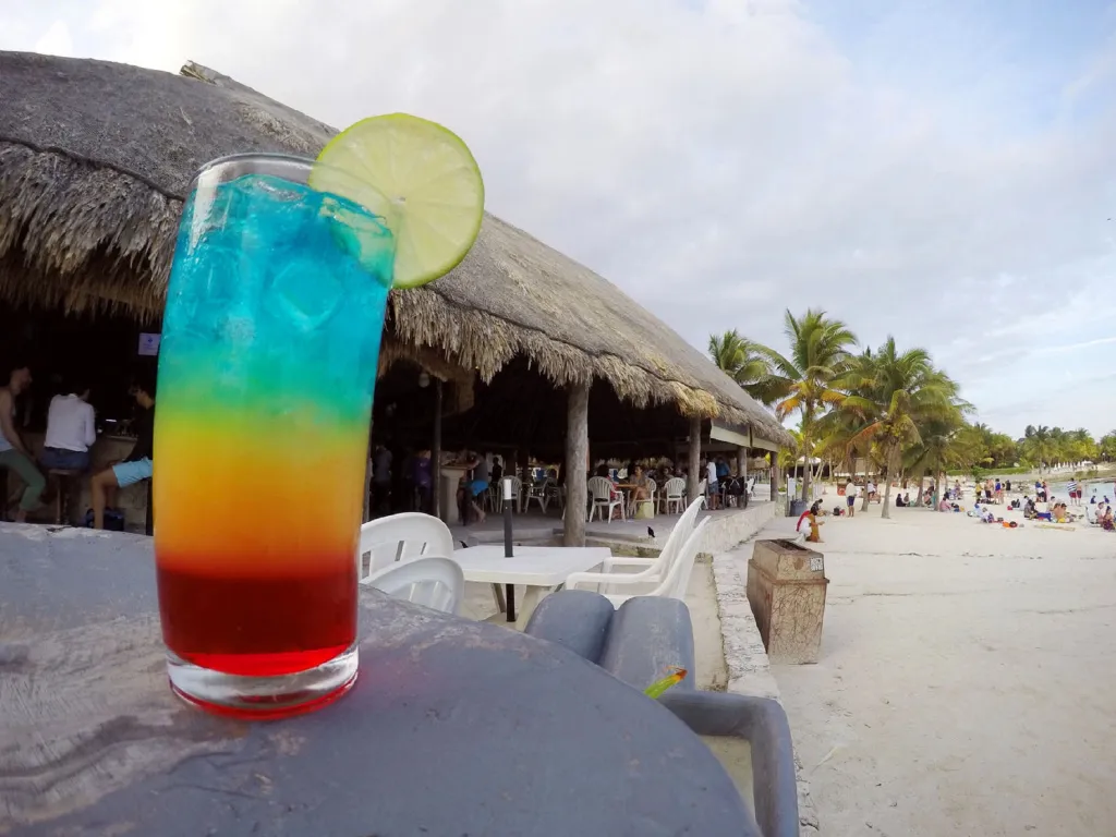 Un cocktail coloré sur une table basse en bord de mer.