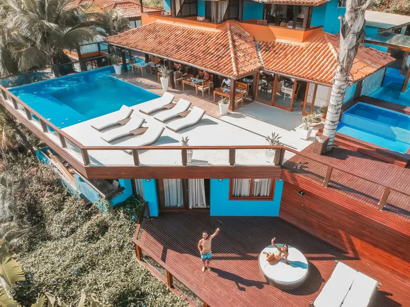 Vue aérienne d'un complexe hôtelier avec piscine et terrasses en bois.