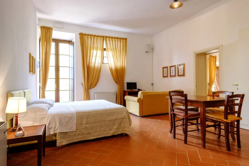 Une chambre lumineuse avec un lit et un coin repas.