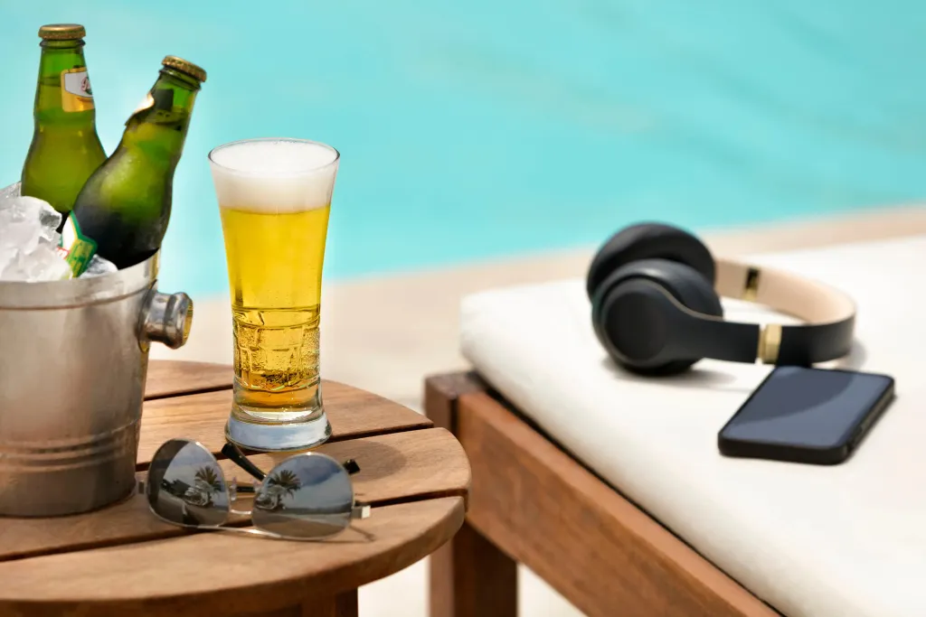 Boissons fraîches et accessoires de détente au bord d'une piscine.