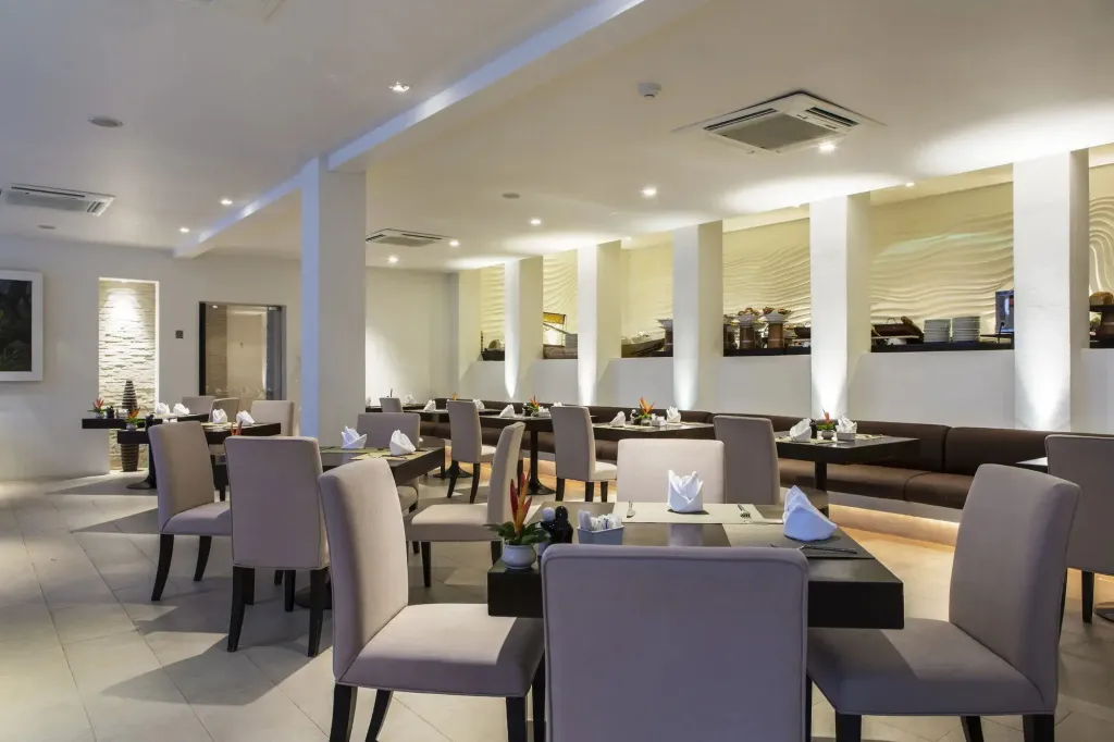 Une salle lumineuse avec des tables dressées pour le repas.